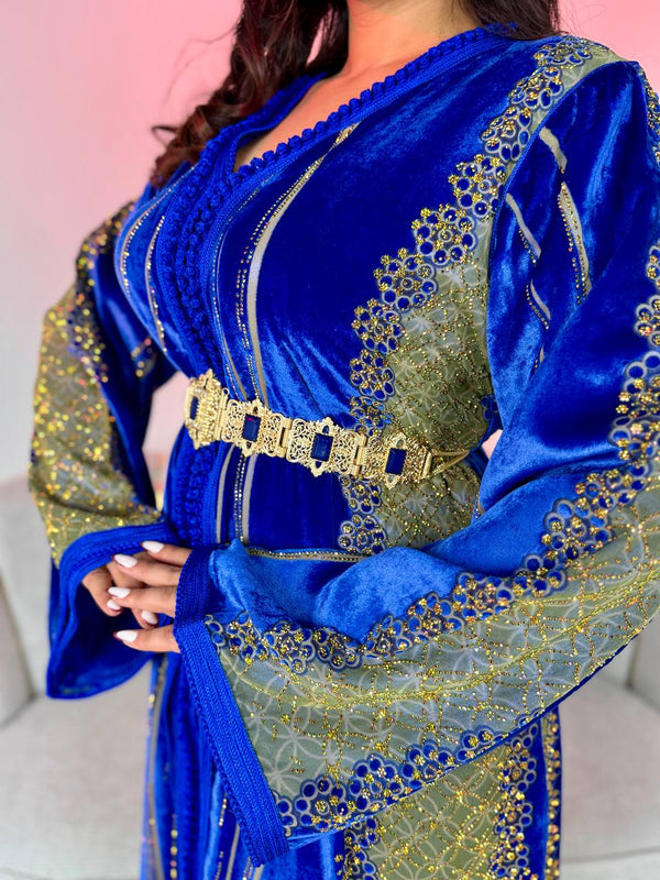 A luxurious royal blue Moroccan takchita crafted from luxurious velvet fabric and hand-embroidered gold, perfect for special occasions.